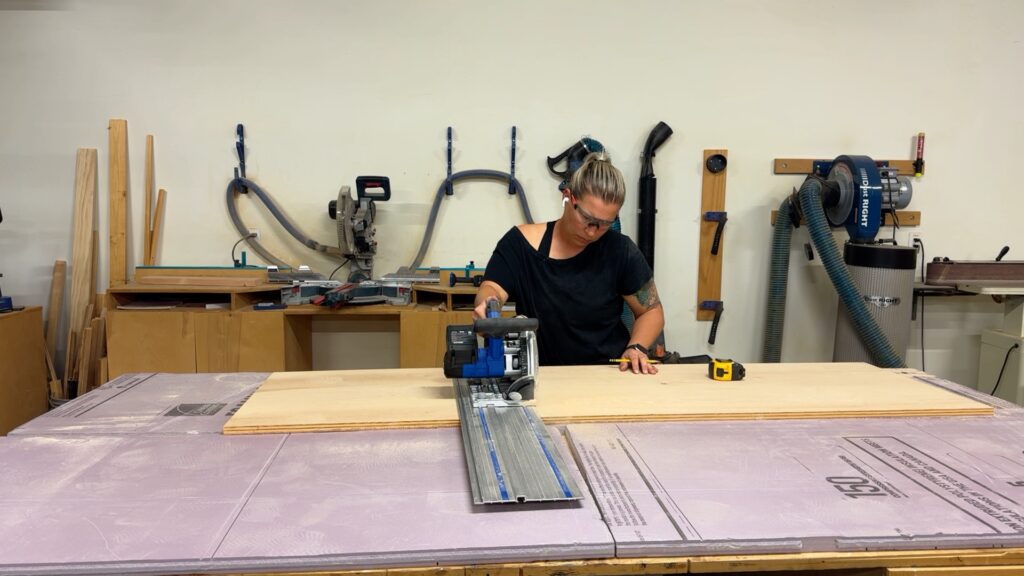 Cutting a sheet of plywood with a track saw for the workbench top and shelving.
