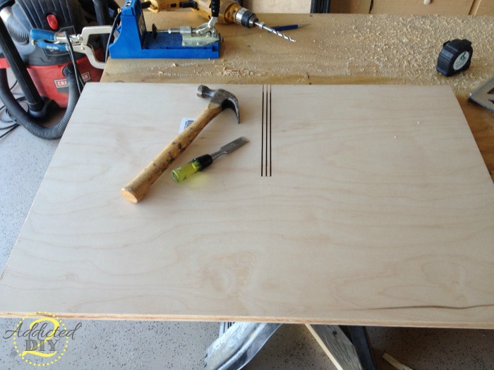 Cutting notches in plywood with a chisel and hammer to create decorative X storage for kitchen island