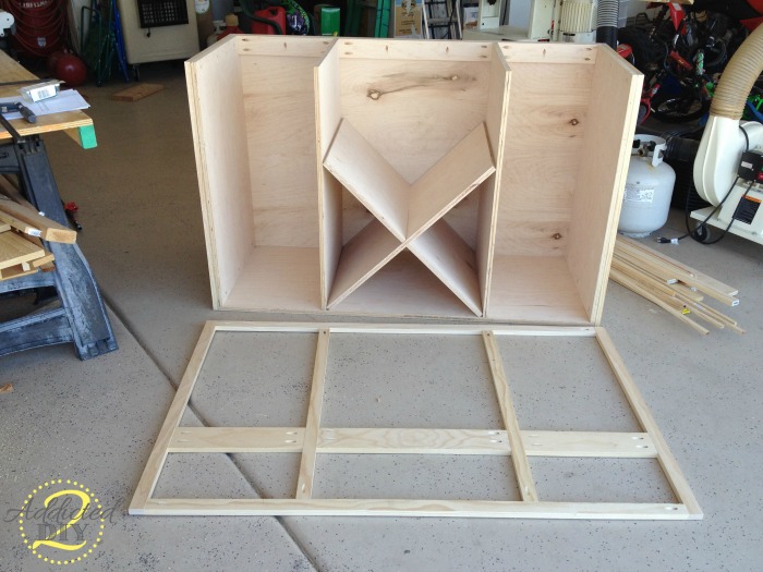 Front face frame laid out in front of unfinished DIY kitchen island cabinet base