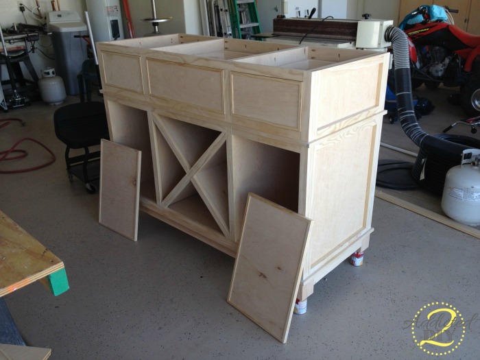 Plywood cabinet doors set in place on unfinished DIY kitchen island before trim and hardware