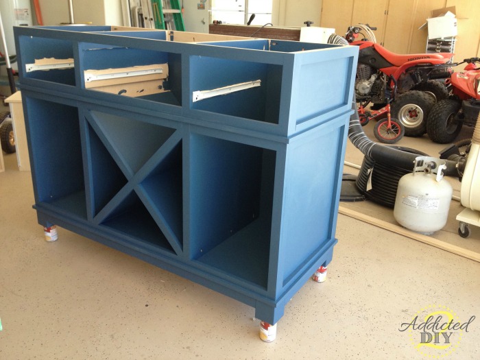 Blue painted DIY kitchen island base before butcher block top, doors, and drawers are installed