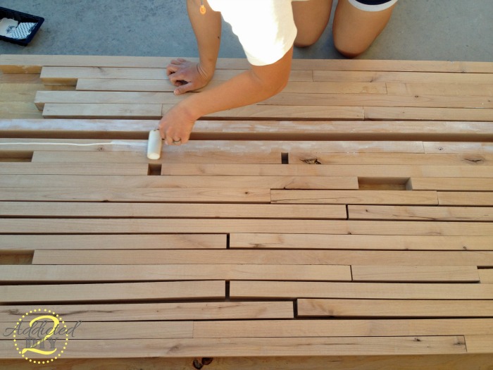 DIY butcher block countertop layout with alder wood strips arranged and glue applied using foam roller before glue-up