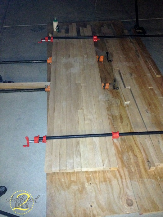 Gluing butcher block countertop boards together using pipe clamps for even pressure during DIY build