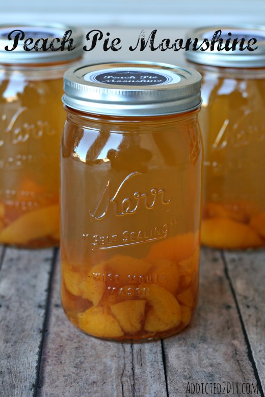 Peach pie moonshine in mason jars with sliced peaches and cinnamon