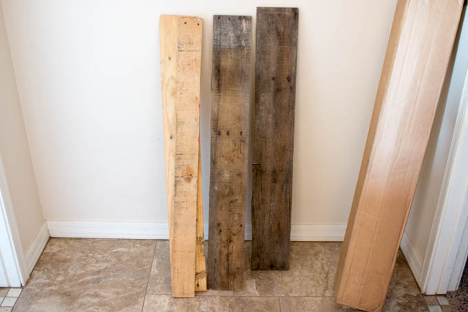 Assorted pallet wood boards in different tones leaning against a wall