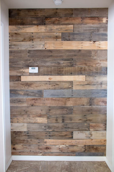 Close-up of finished pallet wall showing varied wood tones and horizontal plank layout
