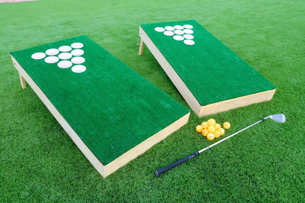Finished DIY chip shot golf game boards set up on grass with golf balls and club