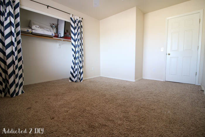 Empty room with beige carpet before installing laminate flooring during office makeover renovation