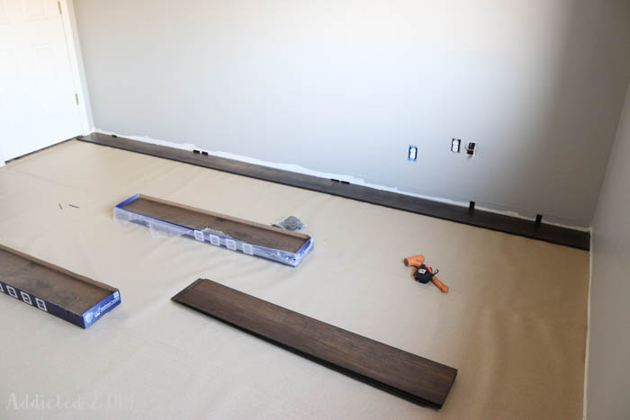 Underlayment installed across room with spacers along wall preparing for laminate flooring installation