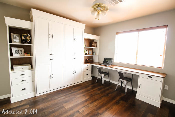 Home office with DIY Murphy bed closed, featuring desk and matching built-in shelving