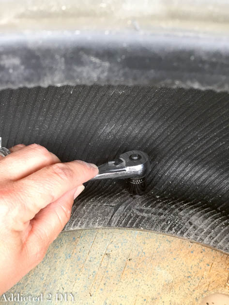 Tightening bolts inside the tire to secure the wood base in place