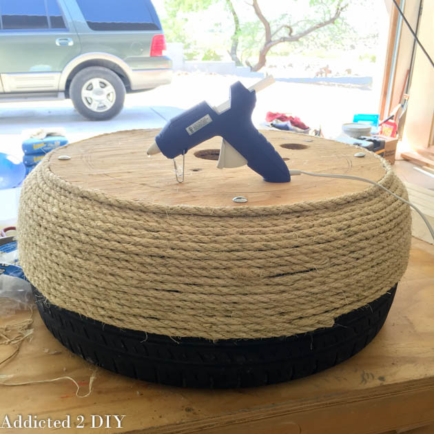 Wrapping sisal rope around an old tire to create a decorative planter