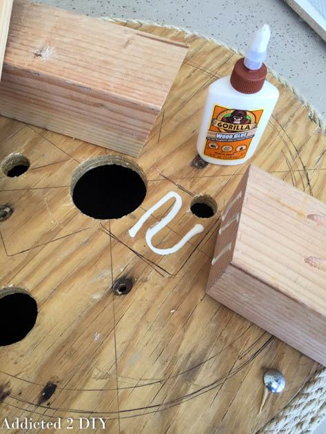 Gluing and positioning the wooden legs on the bottom of the tire planter