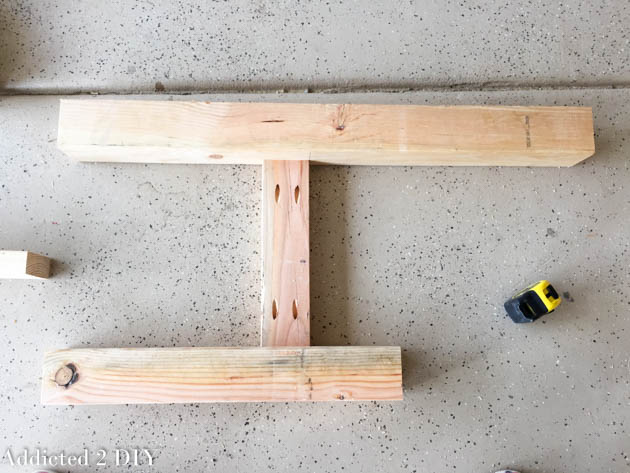Bench side frame assembled from 2x4 boards with pocket holes, laid out on a garage floor before full assembly.