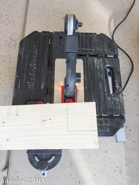 Close-up of a wood board marked for notching on a compact table saw for the tailgate bench seat.