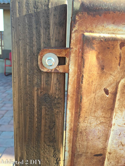 Close-up of a lag bolt and washer attaching the side tab of the vintage tailgate to the bench back post.