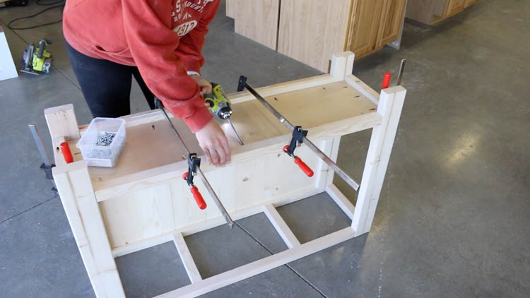 attaching the bottom shelf to the console table with pocket screws