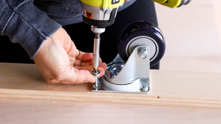 Installing a 3-inch swivel locking caster to the bottom frame of a DIY mobile miter saw bench