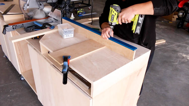 Screwing a double T-track fence cap onto a DIY miter saw bench fence for flip stop installation