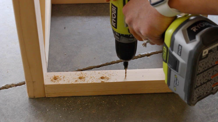 Drilling countersunk pilot holes through stretchers to attach farmhouse console tabletop