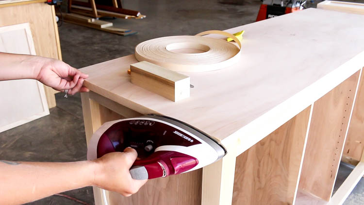 Applying iron-on veneer edge banding to the plywood top of dresser