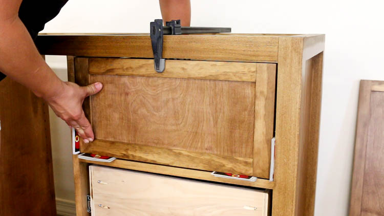 Clamping an inset drawer front in place using playing cards as spacers for even gaps on a DIY rustic dresser