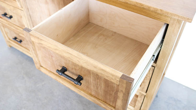 Close-up of deep plywood drawer box with frame-and-panel drawer front and black iron bar pull on DIY rustic dresser