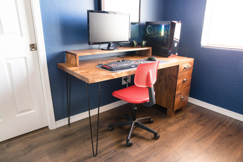Side view of a finished DIY gaming computer desk with hairpin legs and three-drawer cabinet