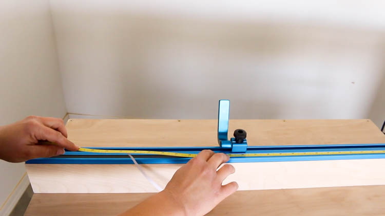 Installing an adhesive tape measure insert into the T-track fence cap on a DIY miter saw bench