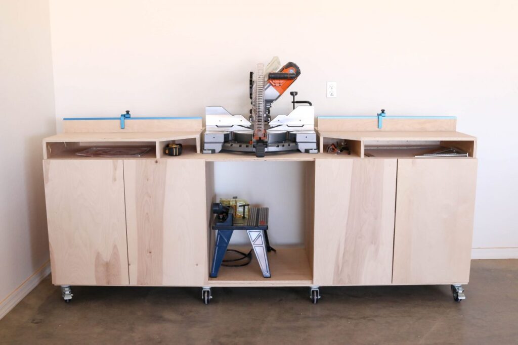 Completed DIY mobile miter saw bench with flip stop fence and pull-out cabinet storage — straight-on front view