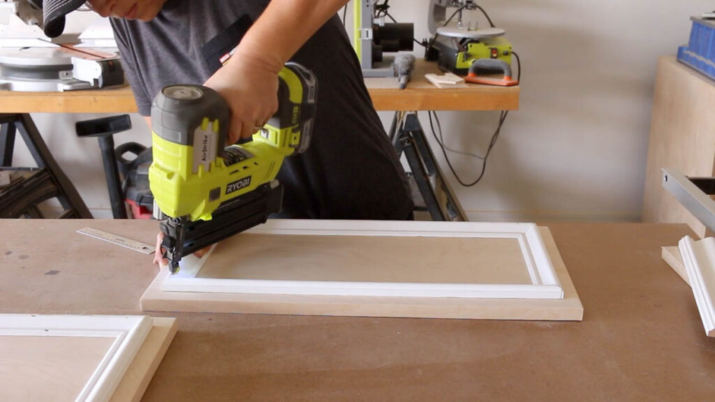 attaching trim to cabinet door frames for the faux fireplace build
