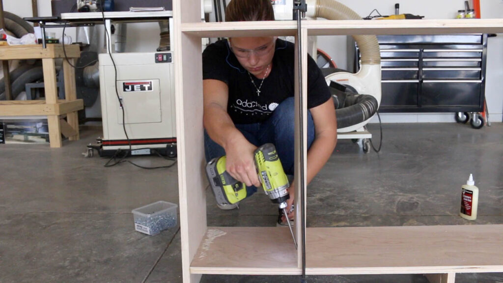 drilling pocket holes to assemble the plywood carcass for a DIY faux fireplace