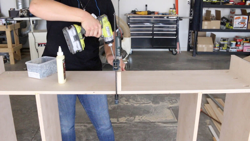attaching the top panel to the faux fireplace frame using pocket screws and clamps