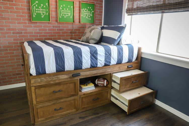 Angled view of a DIY captain's bed showing two step-drawers pulled open, revealing the storage-drawer-as-step design