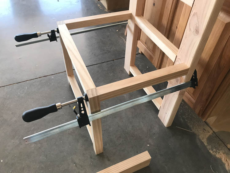 Hall tree bench frame clamped together with bar clamps during assembly