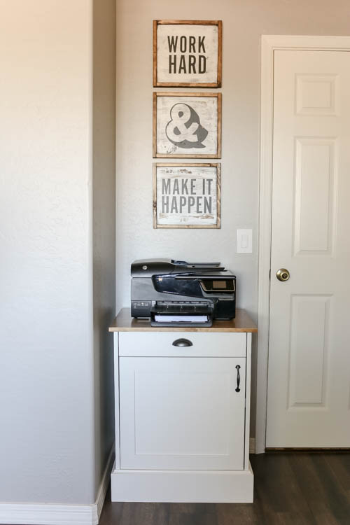 Modern farmhouse printer cabinet styled in a home office corner beneath motivational wall signs reading Work Hard and Make It Happen