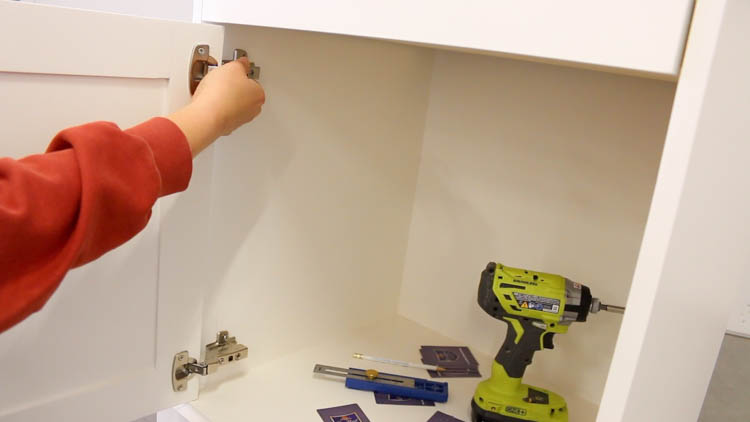 Installing frameless inset hinges on a white painted cabinet door inside a DIY printer cabinet