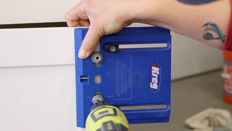 Using a Kreg cabinet hardware jig and Ryobi drill to drill holes for a cabinet pull on a painted drawer front