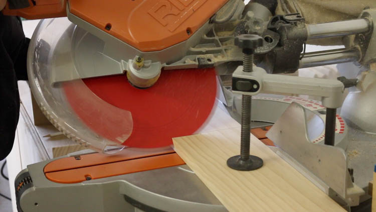 Cutting 45 degree mitered corners on pine moulding for a cabinet base using a Ridgid miter saw