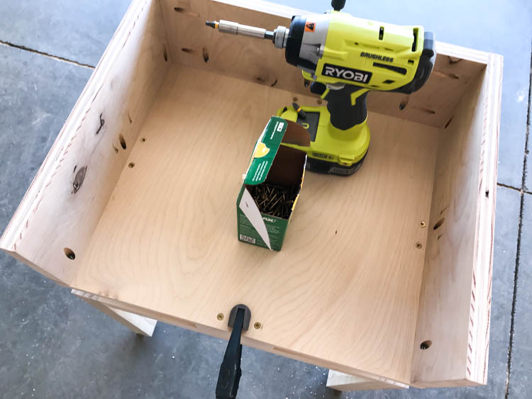 Attaching the plywood nightstand box to the wood base with screws