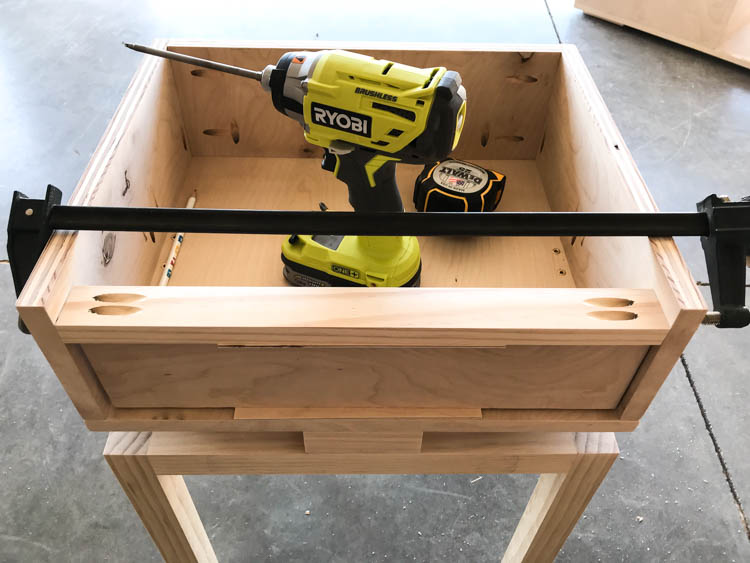 Clamping the drawer front onto the DIY nightstand drawer during assembly