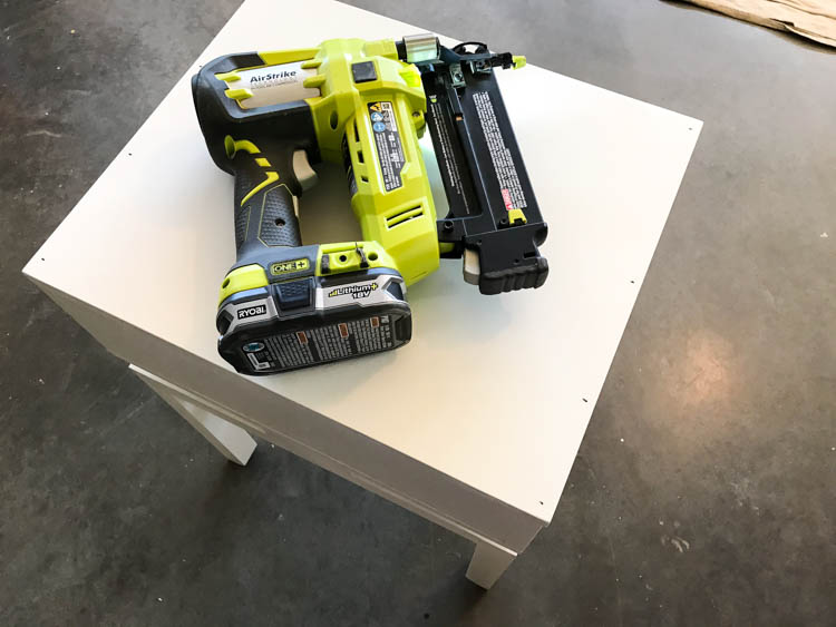 photo of a brad nailer on top of a nightstand where the top was nailed in place