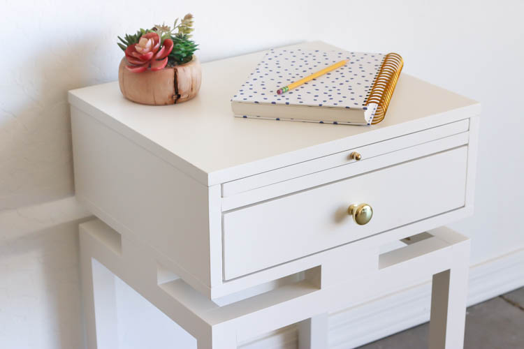 Close-up of a white Anthropologie-inspired DIY nightstand with brass drawer knob