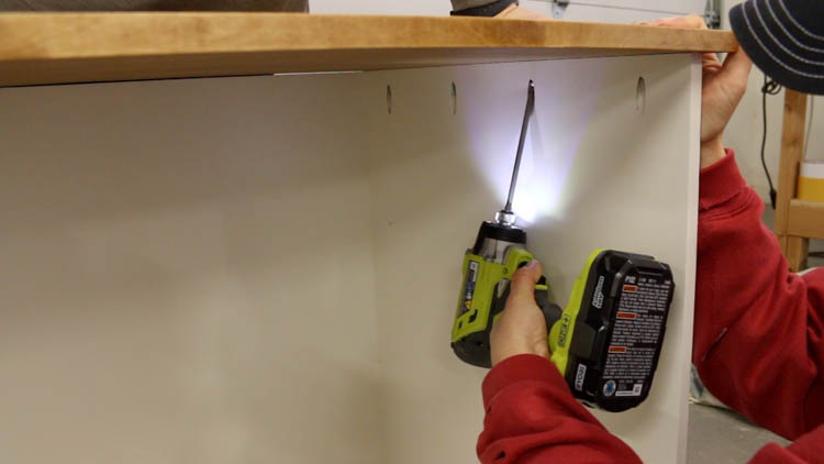 Attaching the walnut stained top to a painted DIY printer cabinet using pocket screws and a Ryobi drill