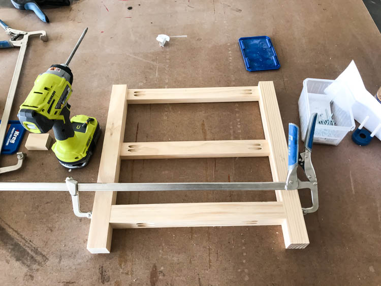 Clamped wood leg supports assembled with pocket holes for DIY storage bench build