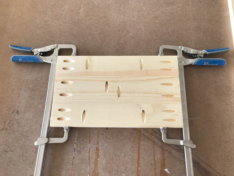 Underside of wood panel showing pocket holes for DIY storage bench assembly