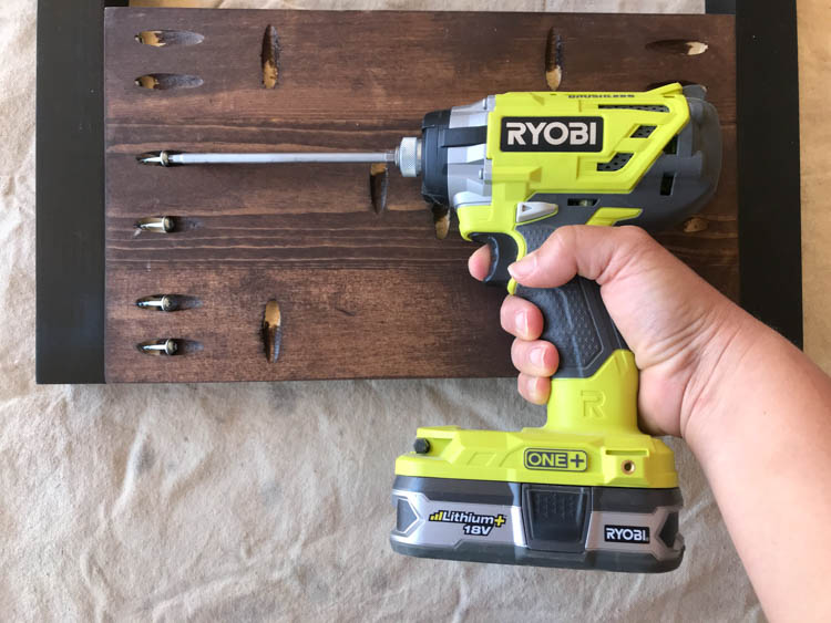 Using an impact driver to assemble stained wood panels for a DIY storage bench