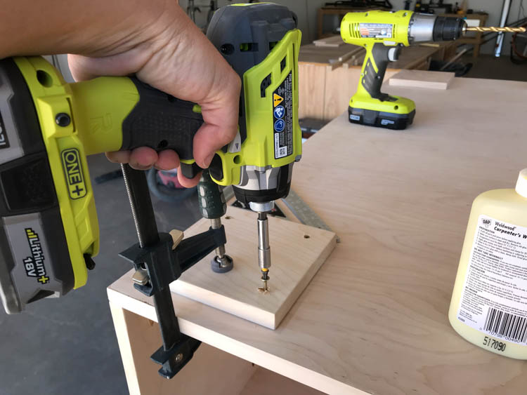 Using a RYOBI Impact Driver to Drive Screws Into the Feet Of the Coffee Table to Attach Them