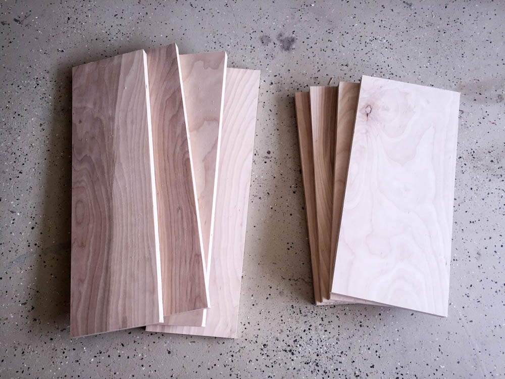 Cut plywood pieces for a DIY kids activity table laid out on a concrete workshop floor ready for assembly