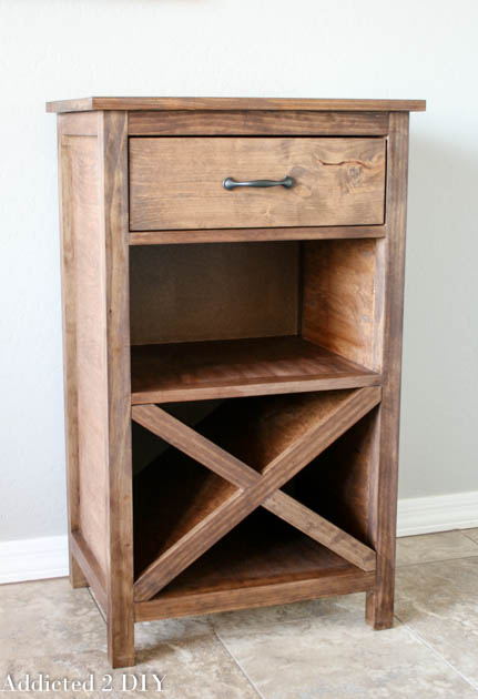 Empty DIY wine cabinet showing X wine rack compartment, open glass storage shelf, and top drawer with black metal bar pull